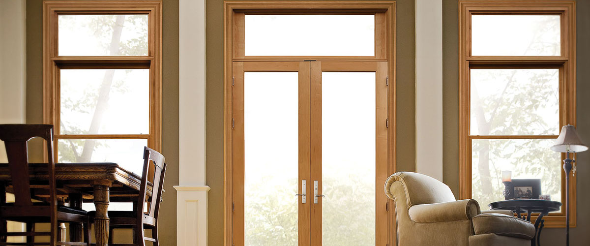 Premium Series Weather Shield French doors with wood grain frame and transom window above.