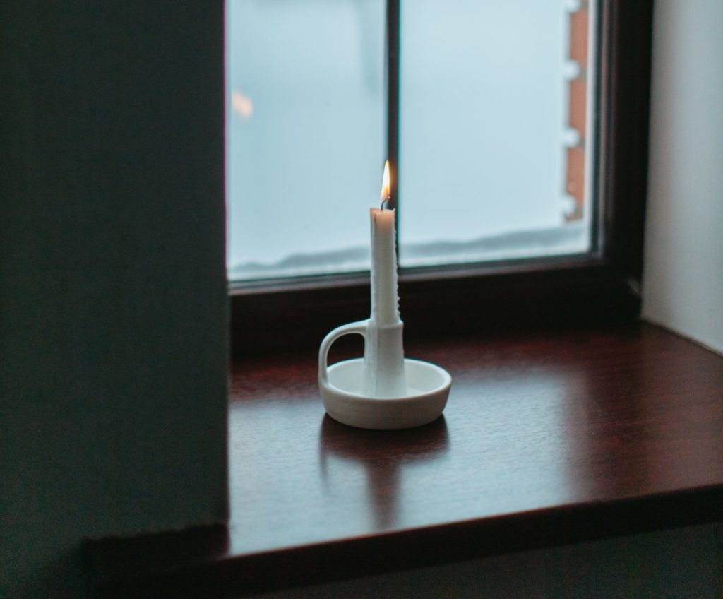 White candle in window.