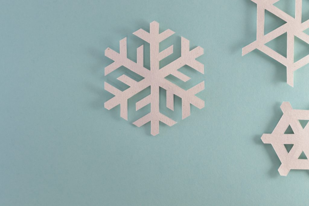Paper snowflake against blue background.